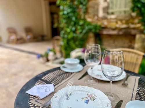 une table avec des verres et des assiettes au-dessus dans l'établissement Suites de Bruoux, à Gargas