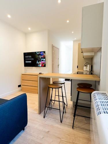 une cuisine avec une table et des tabourets dans une pièce dans l'établissement Suite Palmiers d'Or Cannes, à Cannes