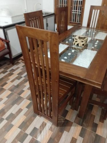 a wooden table with a glass top on a floor at Villa Luxez in Kalmunaikudiyiruppu