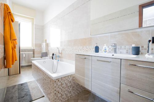 a white bathroom with a tub and a sink at [Reni House]-Bright apartment+free park in Turin