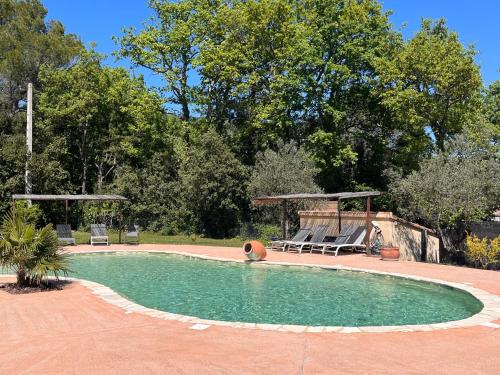 une piscine avec deux chaises et un gazebo dans l'établissement Au Pays de Cocagne, à Nyons