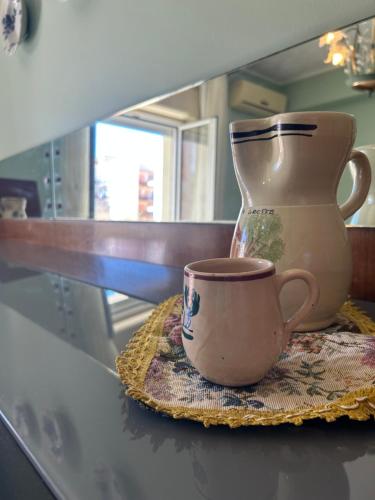 a vase and a cup sitting on a table at Saturno Casa Vacanza in Milazzo
