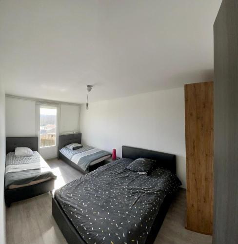 une chambre avec deux lits et une fenêtre dans l'établissement Large single-family home with 4 large bedrooms, à Montbéliard
