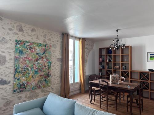 d'un salon avec une table et une peinture murale. dans l'établissement Chic Béziers Town House, à Béziers
