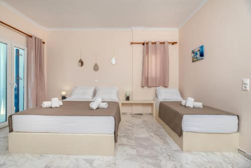 a bedroom with two beds and a window at Villa Margarita in Karterados