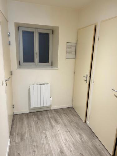 an empty room with a radiator and a window at Studio au centre ville de Dole in Dole