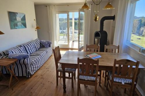 a living room with a table and chairs and a couch at Lütt Haffhus - Haffkrug in Haffkrug