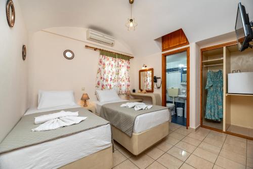 a bedroom with two beds with towels on them at Villa Margarita in Karterados