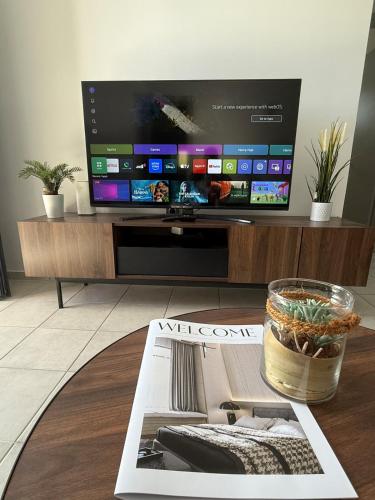 a living room with a tv and a magazine at Trifhouse - Village and Sea escape in Neochórion