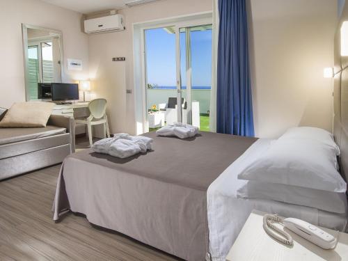 1 dormitorio con 1 cama y escritorio con ordenador en New Hotel Chiari en Cervia