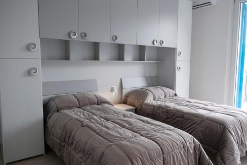 deux lits sont dans une chambre aux murs blancs dans l'établissement Magia home, à Caserte