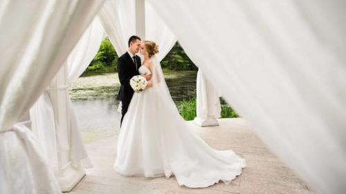 a bride and groom standing under a white canopy at Crowne Plaza Marlow by IHG in Marlow