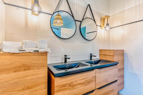 La salle de bains est pourvue de 2 miroirs et d'un lavabo. dans l'établissement Villa Fleurs des Pins, piscine chauffée , 80 m de la plage Pereire, à Arcachon