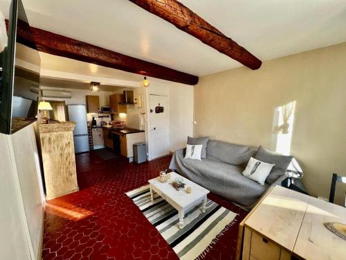 un salon avec un canapé et une table dans l'établissement Appartement T2 - Côté port au coeur de Bandol, à Bandol