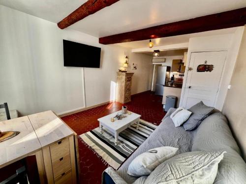 un salon avec un canapé et une table dans l'établissement Appartement T2 - Côté port au coeur de Bandol, à Bandol