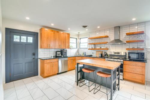 a large kitchen with wooden cabinets and a blue door at 2 Mi to Pleasure Pier Pet-Friendly Gem with Yard in Galveston