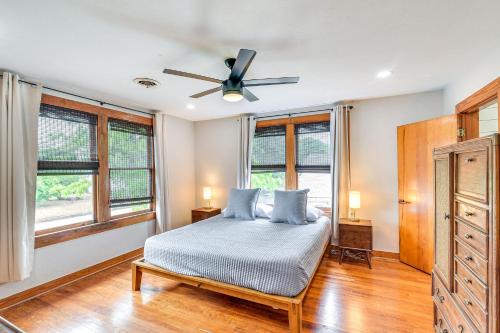 a bedroom with a bed and a ceiling fan at 2 Mi to Pleasure Pier Pet-Friendly Gem with Yard in Galveston