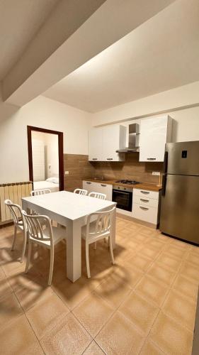 a kitchen with a table and chairs and a refrigerator at Casa vacanza Stella in Torre Forte