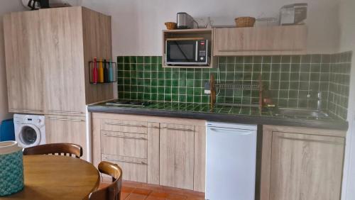 une cuisine avec du carrelage vert au mur et un micro-ondes dans l'établissement studio 16 résidence l'espadon, à Saint-Tropez