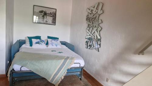 une chambre avec un lit avec des oreillers bleus et blancs dans l'établissement studio 16 résidence l'espadon, à Saint-Tropez