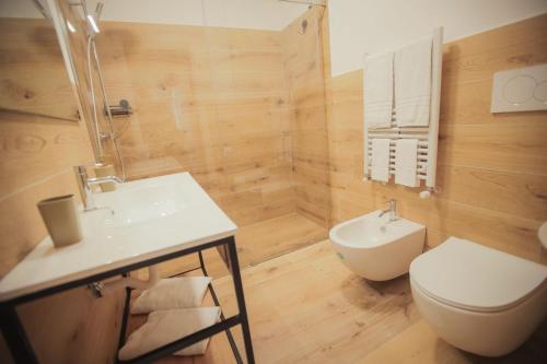 a bathroom with a white toilet and a sink at La finestra sugli ulivi in Pezze di Greco