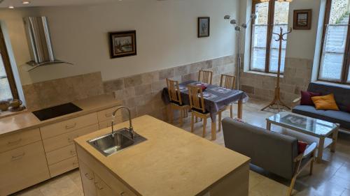 kuchnia i salon ze stołem i kanapą w obiekcie La Maison d'à Côté w mieście Saint-Amand-en-Puisaye