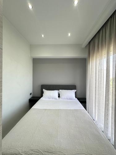 a bedroom with a large bed and a window at Artemis Azure Escape in Kavala