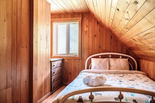 a bedroom with a bed in a wooden cabin at Sous Bois & Loft - Hot tub - Ski out in Mont-Blanc