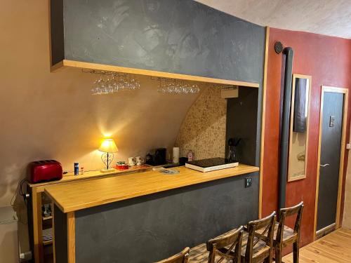 une cuisine avec un comptoir avec des chaises et des verres à vin dans l'établissement Studio Le petit marronnier 2-4 personnes, à La Gaude