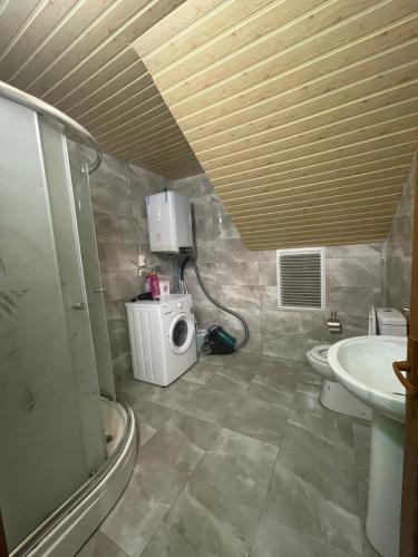 a bathroom with a sink and a washing machine at Su Apart in Rize