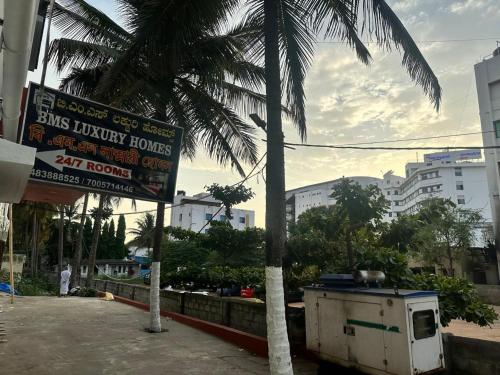 a street sign and a palm tree in a city at BMS Luxury Homes in Bengaluru