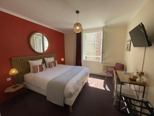 a bedroom with a bed and a table and a mirror at Le Trouville - Hôtel de Charme in Trouville-sur-Mer
