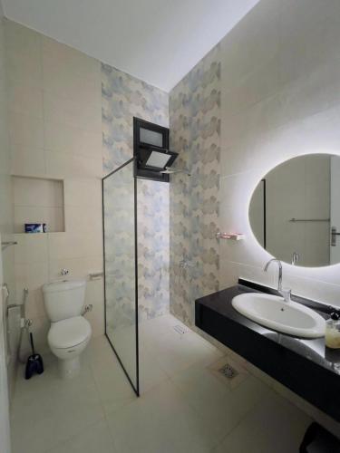 Un baño con inodoro, lavabo y espejo. en Villa Kayan, en Luxor