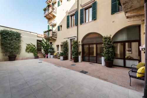 un cortile in un edificio con piante in vaso di PALAZZO RISTORI a Verona