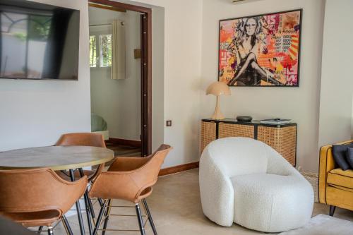 - un salon avec une chaise blanche et une table dans l'établissement La Bastide Petite - Villa au Coeur de Saint-Tropez, à Saint-Tropez
