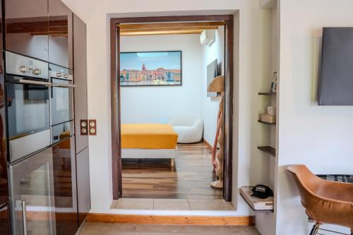 un couloir avec une porte menant à une chambre dans l'établissement La Bastide Petite - Villa au Coeur de Saint-Tropez, à Saint-Tropez
