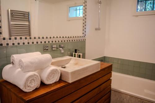 La salle de bains est pourvue d'un lavabo et de serviettes sur un comptoir en bois. dans l'établissement La Bastide Petite - Villa au Coeur de Saint-Tropez, à Saint-Tropez