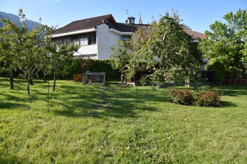a yard with trees in front of a house at Angerburg Blumenhotel in Appiano sulla Strada del Vino