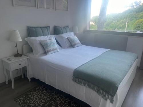a bedroom with a large white bed with a window at Eva apartment Bocca di Magra in Bocca di Magra
