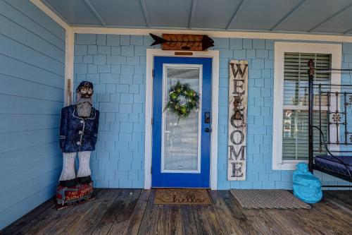 a front door of a blue house with a scarecrow at Blue Heaven by Bolivar Escapes in Crystal Beach