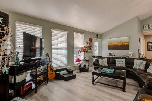 a living room with a couch and a flat screen tv at Blue Heaven by Bolivar Escapes in Crystal Beach