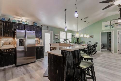 a kitchen with a stainless steel refrigerator and a table at Blue Heaven by Bolivar Escapes in Crystal Beach