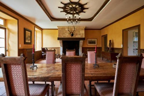 une salle à manger avec une table et des chaises et une cheminée dans l'établissement Manoir de L'Ormel, à Vierville-sur-Mer