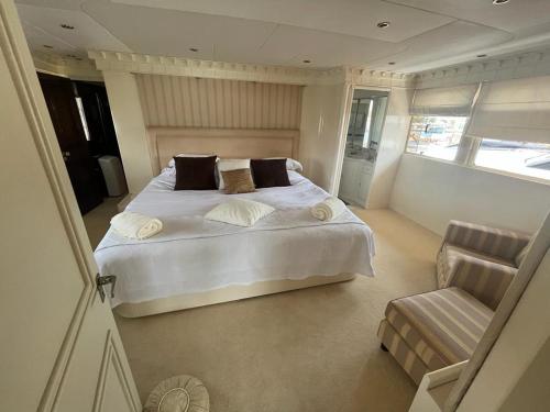 une chambre avec un grand lit blanc et une chaise dans l'établissement MY JoJo, à Cannes