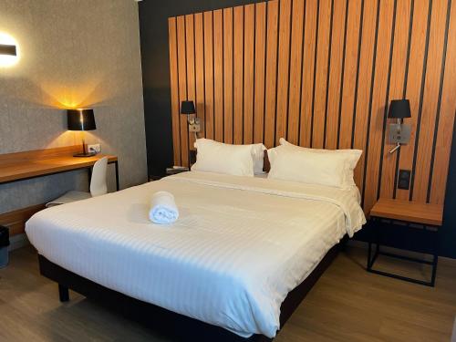 a bedroom with a large white bed with two pillows at Best Western Côte des Sables Plouescat in Plouescat