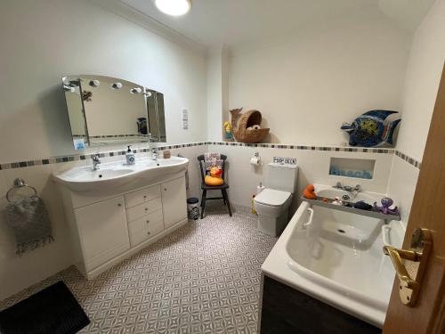 ein Badezimmer mit Waschbecken, Toilette und Spiegel in der Unterkunft Luxury Seaside Home with Incredible Views in Fife