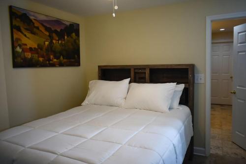a bedroom with a large white bed with a painting on the wall at Marietta Hideaway in Marietta
