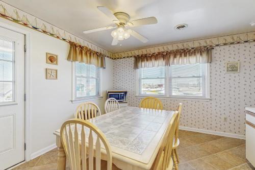 a dining room with a table and chairs and a ceiling fan at 37534 Lighthouse Rd #202 in Fenwick Island