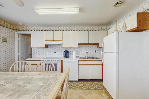 a kitchen with a white refrigerator and a table at 37534 Lighthouse Rd #202 in Fenwick Island