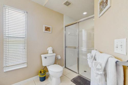Un baño con inodoro y ducha de cristal. en Marco Sands, en Marco Island